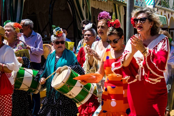 Seville, İspanya - 5 Mayıs 2022 Sevilla 'lılar geleneksel Endülüs tarzında giyinmiş Feria de Seville koridorlarında dolaşıyorlar.
