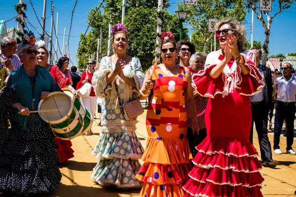 Seville, İspanya - 5 Mayıs 2022 Sevilla 'lılar geleneksel Endülüs tarzında giyinmiş Feria de Seville koridorlarında dolaşıyorlar.
