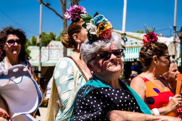 Seville, İspanya - 5 Mayıs 2022 Sevilla 'lılar geleneksel Endülüs tarzında giyinmiş Feria de Seville koridorlarında dolaşıyorlar.
