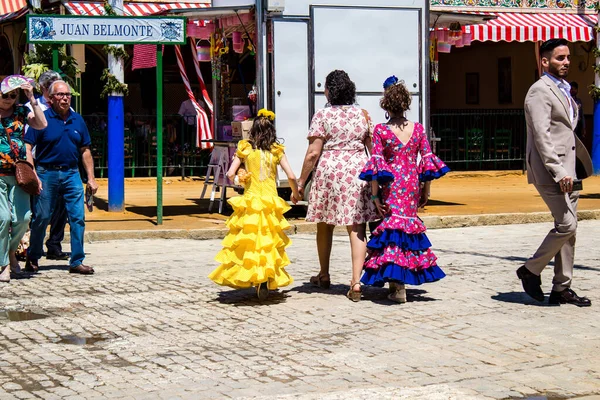 Seville, İspanya - 5 Mayıs 2022 Sevilla 'lılar geleneksel Endülüs tarzında giyinmiş Feria de Seville koridorlarında dolaşıyorlar.