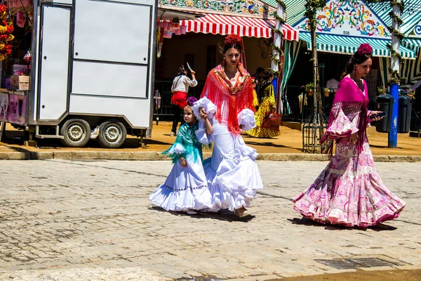Seville, İspanya - 5 Mayıs 2022 Sevilla 'lılar geleneksel Endülüs tarzında giyinmiş Feria de Seville koridorlarında dolaşıyorlar.