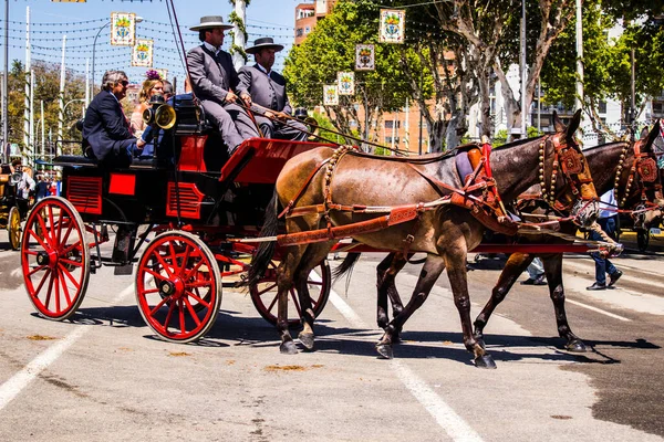 セビリア スペイン 2022年5月5日スペインで最も有名なフェリア セビリアの通路を通って馬車に乗る伝統的なアンダルシアの方法で身を包んだセビリア人 — ストック写真