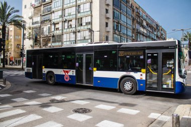 Tel Aviv, Israel - May 07, 2022 Israeli public bus driving through the streets of Tel Aviv during the coronavirus outbreak hitting Israel, wearing a mask is mandatory
