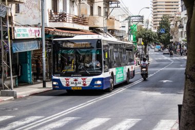 Tel Aviv, Israel - May 07, 2022 Israeli public bus driving through the streets of Tel Aviv during the coronavirus outbreak hitting Israel, wearing a mask is mandatory