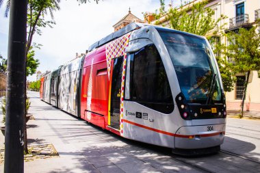 Seville, Spain - May 09, 2022 Modern electric tram for passengers rolling through the streets of Seville during the coronavirus outbreak hitting Spain, wearing a mask is mandatory
