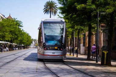 Seville, Spain - May 09, 2022 Modern electric tram for passengers rolling through the streets of Seville during the coronavirus outbreak hitting Spain, wearing a mask is mandatory