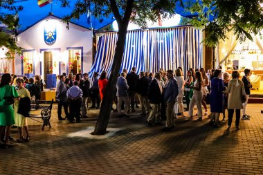 Carmona, İspanya - 11 Mayıs 2022, Feria de Carmona, insanlar arkadaşlarıyla içki içip flamenko dansı yapıyorlar, bu kutlama iki yıllık yokluğun ardından bir covid salgını nedeniyle geri döndü.