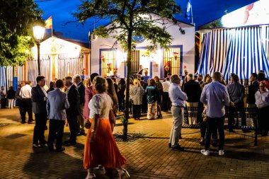 Carmona, İspanya - 11 Mayıs 2022, Feria de Carmona, insanlar arkadaşlarıyla içki içip flamenko dansı yapıyorlar, bu kutlama iki yıllık yokluğun ardından bir covid salgını nedeniyle geri döndü.