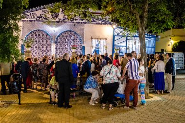 Carmona, İspanya - 11 Mayıs 2022, Feria de Carmona, insanlar arkadaşlarıyla içki içip flamenko dansı yapıyorlar, bu kutlama iki yıllık yokluğun ardından bir covid salgını nedeniyle geri döndü.