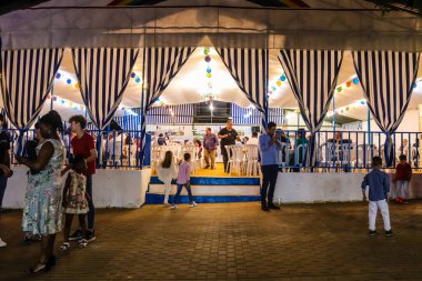 Carmona, İspanya - 11 Mayıs 2022, Feria de Carmona, insanlar arkadaşlarıyla içki içip flamenko dansı yapıyorlar, bu kutlama iki yıllık yokluğun ardından bir covid salgını nedeniyle geri döndü.