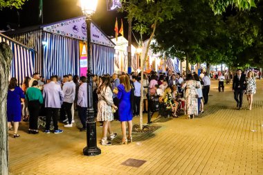 Carmona, İspanya - 11 Mayıs 2022, Feria de Carmona, insanlar arkadaşlarıyla içki içip flamenko dansı yapıyorlar, bu kutlama iki yıllık yokluğun ardından bir covid salgını nedeniyle geri döndü.