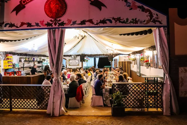 Carmona, İspanya - 11 Mayıs 2022, Feria de Carmona, insanlar arkadaşlarıyla içki içip flamenko dansı yapıyorlar, bu kutlama iki yıllık yokluğun ardından bir covid salgını nedeniyle geri döndü.