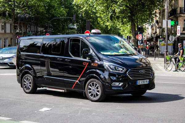 Paris, France - May 21, 2022 Taxi driving through the streets of Paris during the coronavirus outbreak hitting France, wearing a mask is mandatory