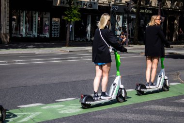 Paris, Fransa - 21 Mayıs 2022 Paris sokaklarında elektrikli scooterla dolaşan insanlar, küçük bir iç yanmalı motorlar ve merkezde bir güverte ile çalışıyorlar.