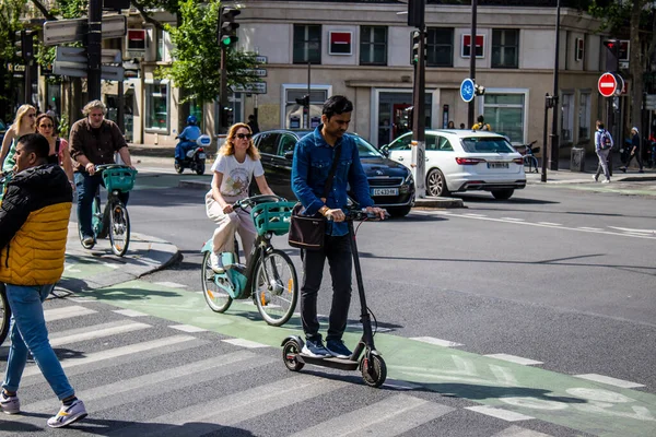 Paris, Fransa - 21 Mayıs 2022 Paris sokaklarında elektrikli scooterla dolaşan insanlar, küçük bir iç yanmalı motorlar ve merkezde bir güverte ile çalışıyorlar.