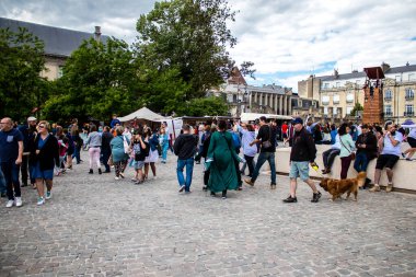Reims, Fransa - 28 Mayıs 2022 Johanniques şenlikleri sırasında ortaçağ pazarında gezinen ziyaretçiler, Coronavirus salgınının ardından iki yıllık bir aradan sonra geri döndüler.