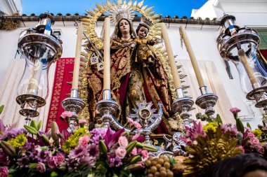 Carmona, İspanya - 19 Haziran 2022 Corpus Christi de Carmona, Santa Maria Kilisesi 'ne giden dini geçit töreni, dini heykeller, küçük çocuklar, Hıristiyanlar ve bir müzik grubundan oluşuyor.