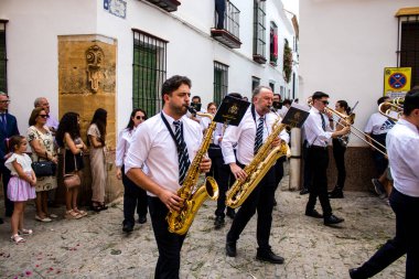 Carmona, İspanya - 19 Haziran 2022 Carmona Corpus Christi, Santa Maria Kilisesi 'ne giden dini geçit töreni, dini heykeller, küçük çocuklar, Hıristiyanlar ve bir müzik grubundan oluşuyor.