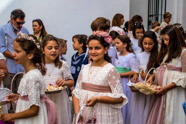 Carmona, İspanya - 19 Haziran 2022 Corpus Christi de Carmona, çocuklarla birlikte Santa Maria Kilisesi 'ne yapılan dini geçit töreni.