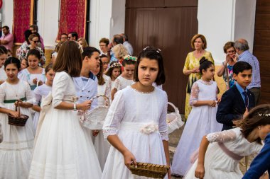 Carmona, İspanya - 19 Haziran 2022 Corpus Christi de Carmona, çocuklarla birlikte Santa Maria Kilisesi 'ne yapılan dini geçit töreni.