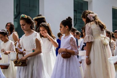 Carmona, İspanya - 19 Haziran 2022 Carmona Corpus Christi, Santa Maria Kilisesi 'ne giden genç çocuklarla dolu dini geçit töreni.