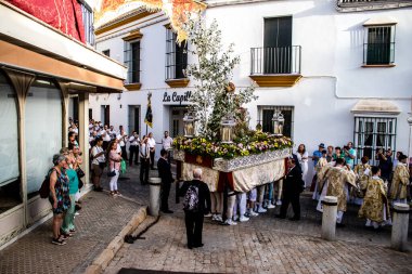Carmona, İspanya - 18 Haziran 2022 Carmona Corpus Christi, sokaklardaki dini tören alayı, San Blas Virgen kilisesinden Santa Maria kilisesine transfer, insanlar yolda dua ediyorlar.