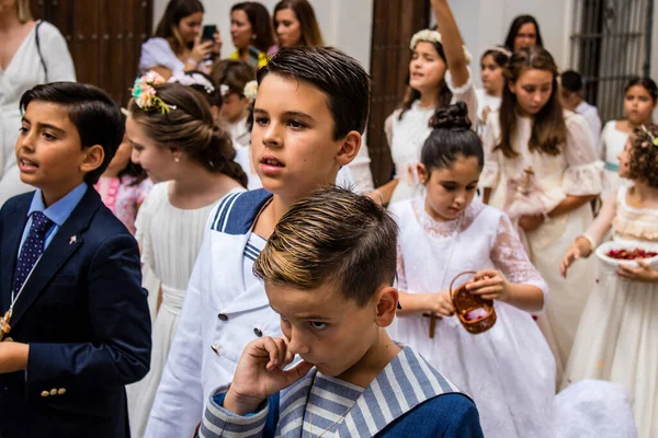 Carmona, İspanya - 19 Haziran 2022 Carmona Corpus Christi, Santa Maria Kilisesi 'ne giden genç çocuklarla dolu dini geçit töreni.