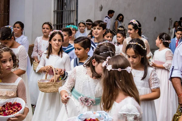 Carmona, İspanya - 19 Haziran 2022 Carmona Corpus Christi, Santa Maria Kilisesi 'ne giden genç çocuklarla dolu dini geçit töreni.