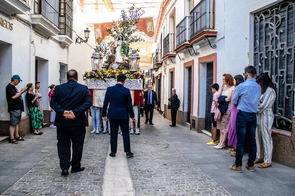 Carmona, İspanya - 18 Haziran 2022 Carmona Corpus Christi, sokaklardaki dini tören alayı, San Blas Virgen kilisesinden Santa Maria kilisesine transfer, insanlar yolda dua ediyorlar.