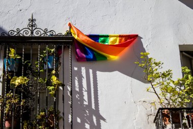 Seville, İspanya - 25 Haziran 2022 LBGT bayrağı, İspanya 'nın güneyinde, sembolik bir şehir ve Endülüs Bölgesi' nin başkenti olan Sevilla sokaklarındaki bir binanın ön cephesinde