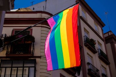Seville, İspanya - 25 Haziran 2022 LBGT bayrağı, İspanya 'nın güneyinde, sembolik bir şehir ve Endülüs Bölgesi' nin başkenti olan Sevilla sokaklarındaki bir binanın ön cephesinde