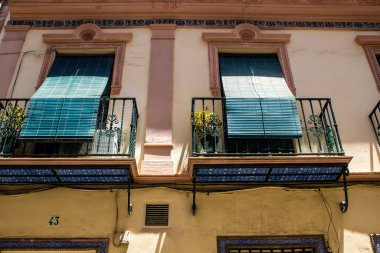 Seville, İspanya - 4 Temmuz 2022 İspanya 'nın güneyindeki Endülüs Bölgesi' nin başkenti ve sembolik bir şehir olan Sevilla sokaklarındaki bir binanın cephesi