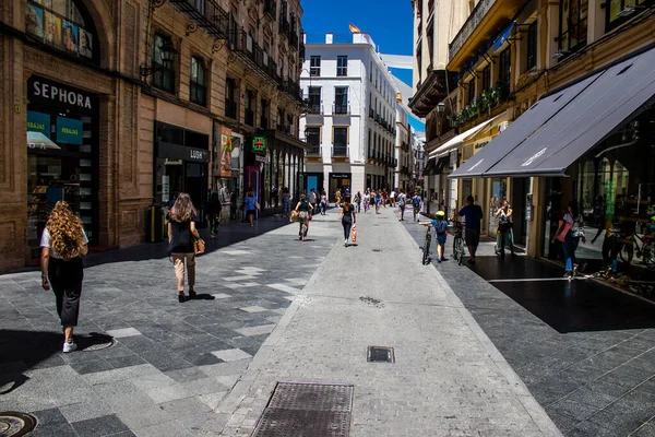 Seville, Spain - July 04, 2022 Pedestrians shopping in the main commercial street of Seville during coronavirus outbreak hitting Spain, wearing a mask in the street is not mandatory