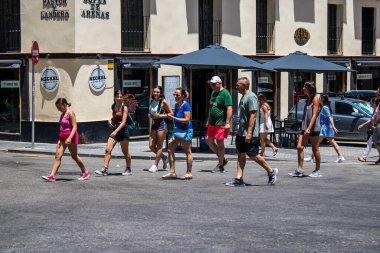 Seville, Spain - July 04, 2022 Pedestrians shopping in the main commercial street of Seville during coronavirus outbreak hitting Spain, wearing a mask in the street is not mandatory