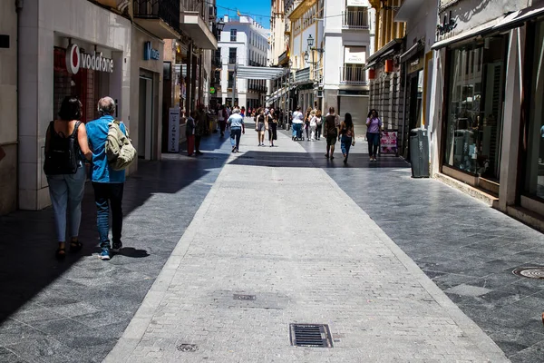 Seville, Spain - July 04, 2022 Pedestrians shopping in the main commercial street of Seville during coronavirus outbreak hitting Spain, wearing a mask in the street is not mandatory