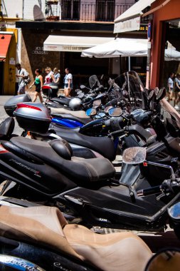 Seville, Spain - July 04, 2022 Scooters parked in the streets of Seville, an emblematic city and the capital of the region of Andalusia
