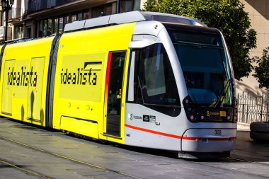 Seville, Spain - July 12, 2022 Modern electric tram for passengers rolling through the streets of Seville during the coronavirus outbreak hitting Spain, wearing a mask is mandatory