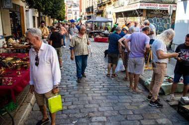 Seville, İspanya - 14 Temmuz 2022 Mercadillo Historico Del Jueves olarak da bilinen bit pazarında satılan çeşitli eşyalar, yerel halk dar Calle Feria 'da pazarlık aramakla meşgul.