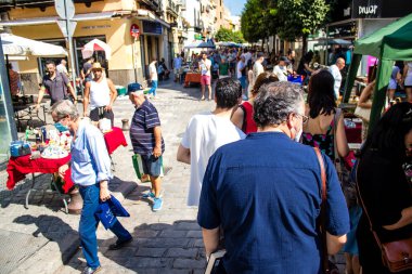 Seville, İspanya - 14 Temmuz 2022 Mercadillo Historico Del Jueves olarak da bilinen bit pazarında satılan çeşitli eşyalar, yerel halk dar Calle Feria 'da pazarlık aramakla meşgul.