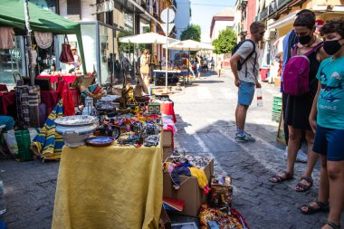 Seville, İspanya - 14 Temmuz 2022 Mercadillo Historico Del Jueves olarak da bilinen bit pazarında satılan çeşitli eşyalar, yerel halk dar Calle Feria 'da pazarlık aramakla meşgul.