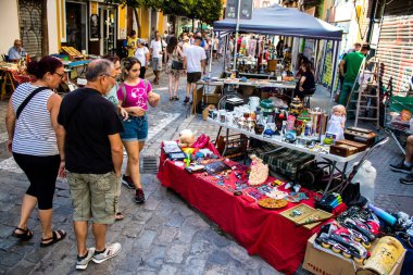 Seville, İspanya - 14 Temmuz 2022 Mercadillo Historico Del Jueves olarak da bilinen bit pazarında satılan çeşitli eşyalar, yerel halk dar Calle Feria 'da pazarlık aramakla meşgul.