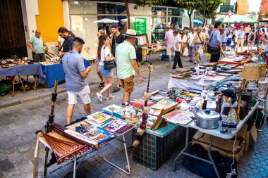 Seville, İspanya - 14 Temmuz 2022 Mercadillo Historico Del Jueves olarak da bilinen bit pazarında satılan çeşitli eşyalar, yerel halk dar Calle Feria 'da pazarlık aramakla meşgul.