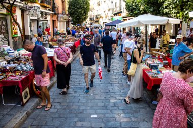 Seville, İspanya - 14 Temmuz 2022 Mercadillo Historico Del Jueves olarak da bilinen bit pazarında satılan çeşitli eşyalar, yerel halk dar Calle Feria 'da pazarlık aramakla meşgul.