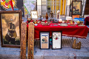 Seville, İspanya - 14 Temmuz 2022 Mercadillo Historico Del Jueves olarak da bilinen bit pazarında satılan çeşitli eşyalar, yerel halk dar Calle Feria 'da pazarlık aramakla meşgul.