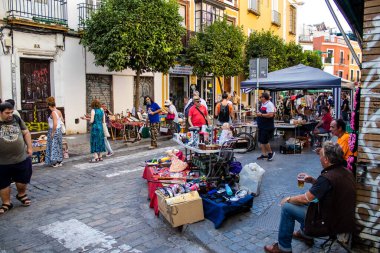 Seville, İspanya - 14 Temmuz 2022 Mercadillo Historico Del Jueves olarak da bilinen bit pazarında satılan çeşitli eşyalar, yerel halk dar Calle Feria 'da pazarlık aramakla meşgul.
