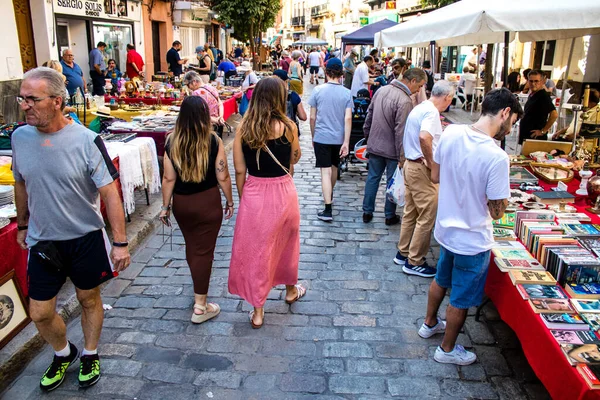 Seville, İspanya - 14 Temmuz 2022 Mercadillo Historico Del Jueves olarak da bilinen bit pazarında satılan çeşitli eşyalar, yerel halk dar Calle Feria 'da pazarlık aramakla meşgul.