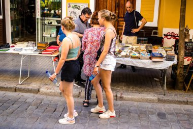 Seville, İspanya - 14 Temmuz 2022 Mercadillo Historico Del Jueves olarak da bilinen bit pazarında satılan çeşitli eşyalar, yerel halk dar Calle Feria 'da pazarlık aramakla meşgul.