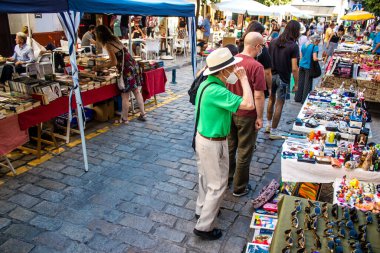 Seville, Spain - July 14, 2022 Various objects sold at the Flea market, also known as Mercadillo Historico Del Jueves, locals are busy poking around looking for bargains in the narrow Calle Feria