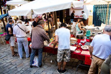 Seville, İspanya - 14 Temmuz 2022 Mercadillo Historico Del Jueves olarak da bilinen bit pazarında satılan çeşitli eşyalar, yerel halk dar Calle Feria 'da pazarlık aramakla meşgul.
