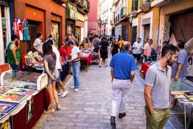 Seville, İspanya - 14 Temmuz 2022 Mercadillo Historico Del Jueves olarak da bilinen bit pazarında satılan çeşitli eşyalar, yerel halk dar Calle Feria 'da pazarlık aramakla meşgul.